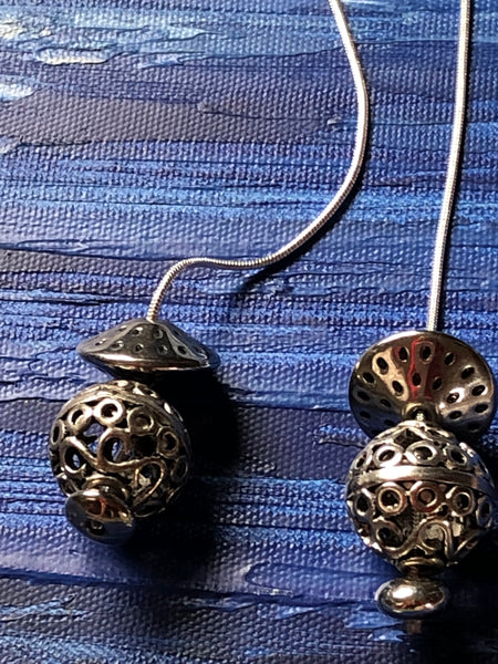 silver laminated finish pendant balls on long snake rope chain.